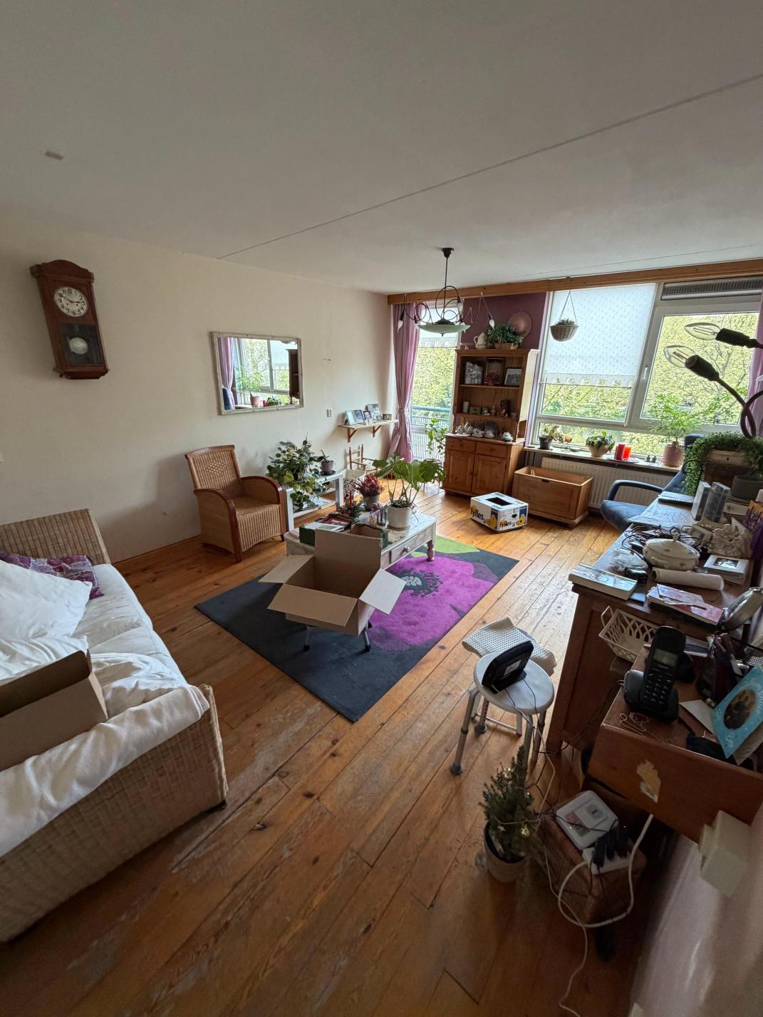 Ingerichte woonkamer met houten vloer in Amsterdam centrum, vóór de woningontruiming